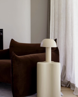 Chocolate armchair beside a cream table lamp, fform